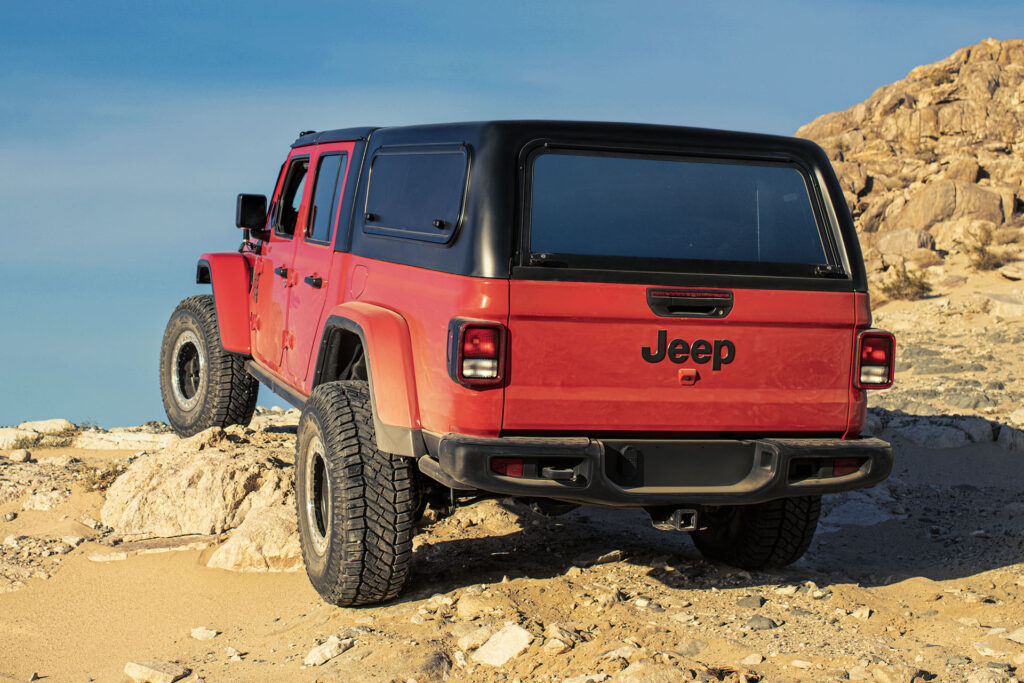 Red Jeep Gladiator in a rocky desert with a Venturous Ozark truck cap